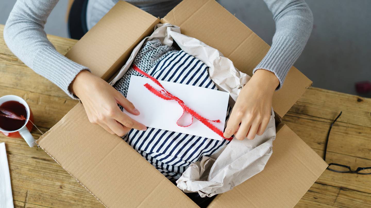 A person wraps a gift in a box.