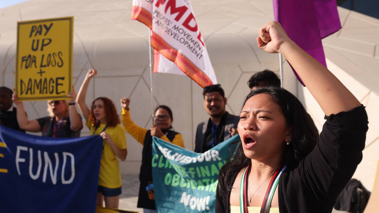 Activists lift placards and chant slogans calling on the world's biggest CO2 emitters to fill the 'Loss and Damage' fund supporting the adaptation and development of countries most vulnerable to climate change, at the COP28 United Nations climate talks in Dubai on December 4, 2023.